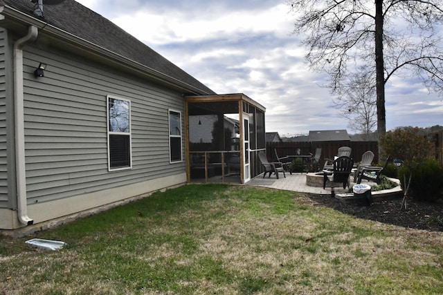 view of yard with a sunroom, a patio area, and an outdoor fire pit