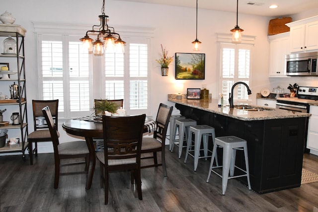 dining space featuring dark hardwood / wood-style floors, a healthy amount of sunlight, and sink