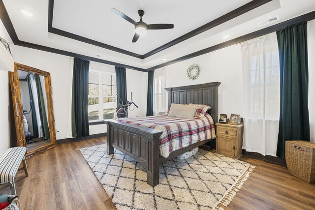 bedroom featuring a tray ceiling, ceiling fan, and hardwood / wood-style flooring