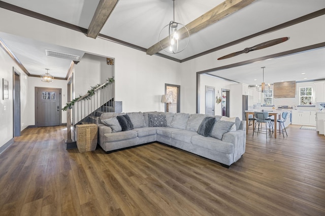 living room with beam ceiling, ornamental molding, and dark wood-type flooring