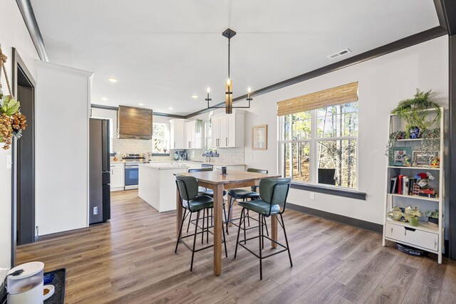 dining area with dark hardwood / wood-style flooring, an inviting chandelier, and crown molding