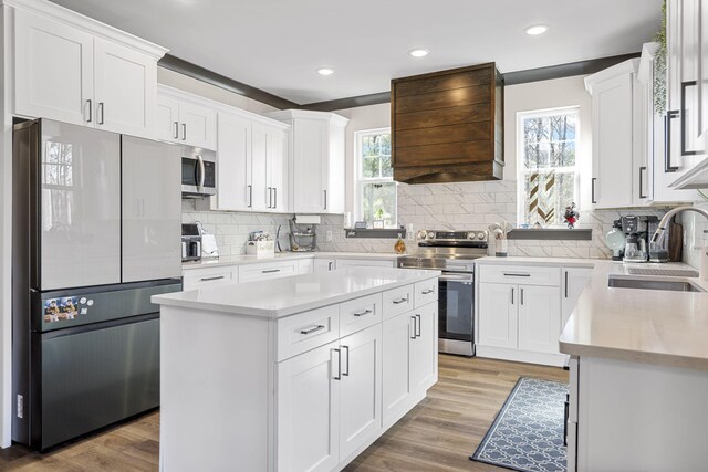 kitchen with a kitchen island, white cabinetry, and appliances with stainless steel finishes