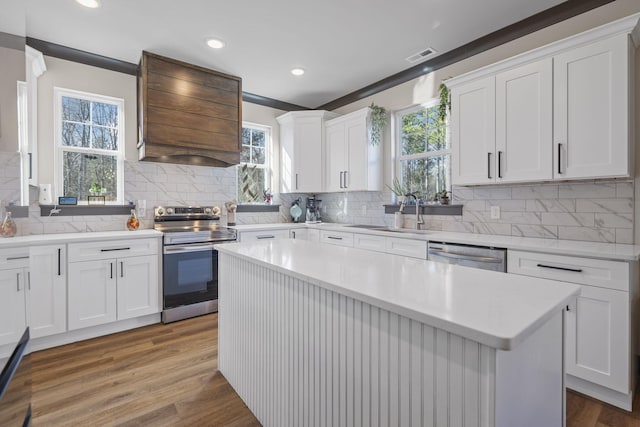 kitchen with white cabinets, sink, stainless steel appliances, and hardwood / wood-style floors