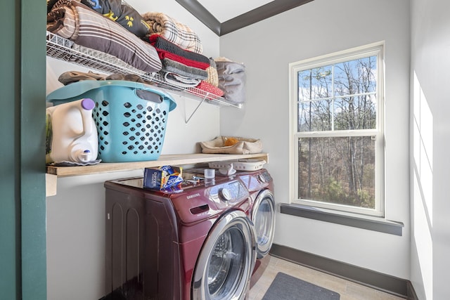 washroom with crown molding, washer and clothes dryer, and a healthy amount of sunlight