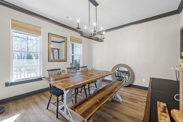 dining room featuring a chandelier, light hardwood / wood-style floors, and crown molding