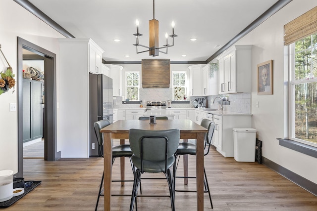 dining space with hardwood / wood-style floors, sink, and a chandelier