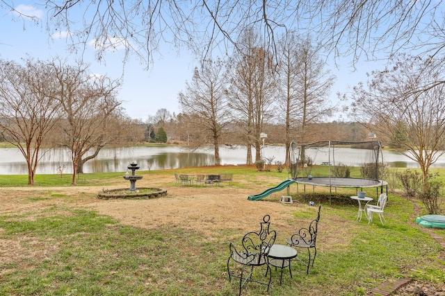 view of yard featuring a trampoline and a water view