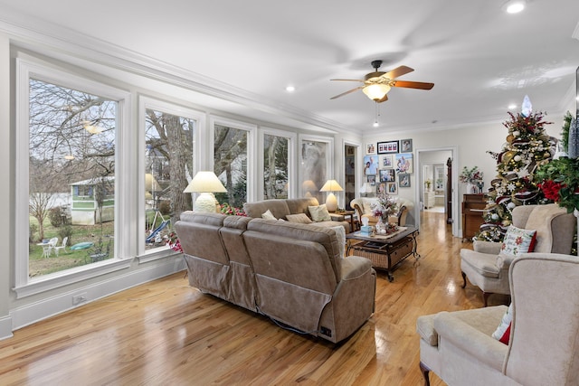 living room with ceiling fan, crown molding, and light wood-type flooring