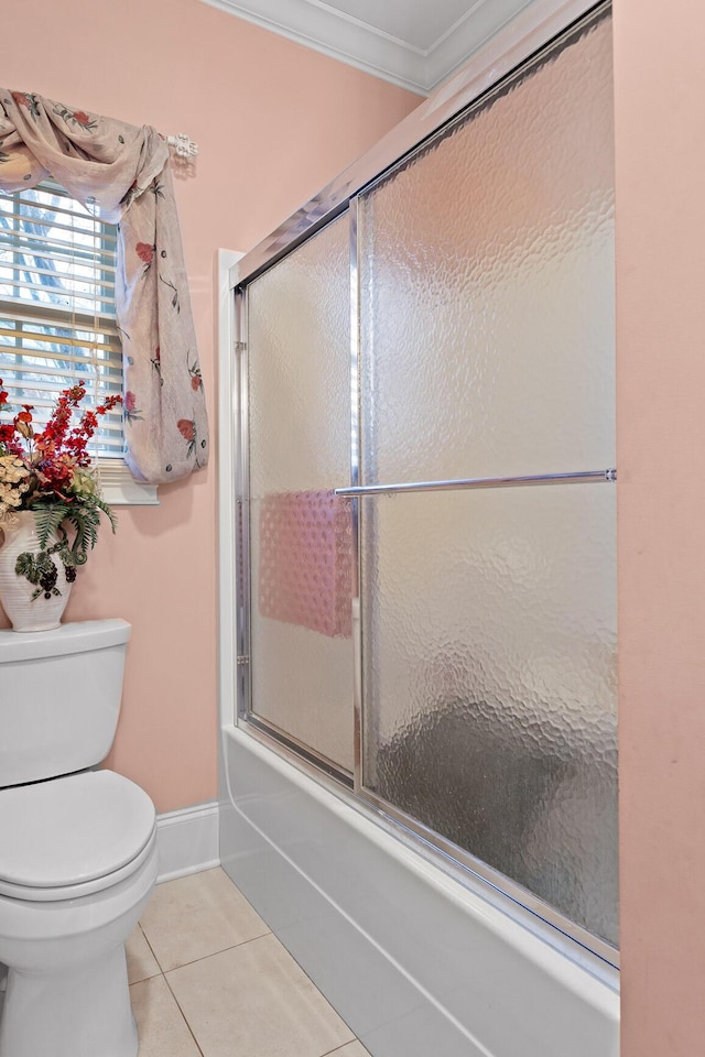 bathroom featuring tile patterned floors, crown molding, enclosed tub / shower combo, and toilet