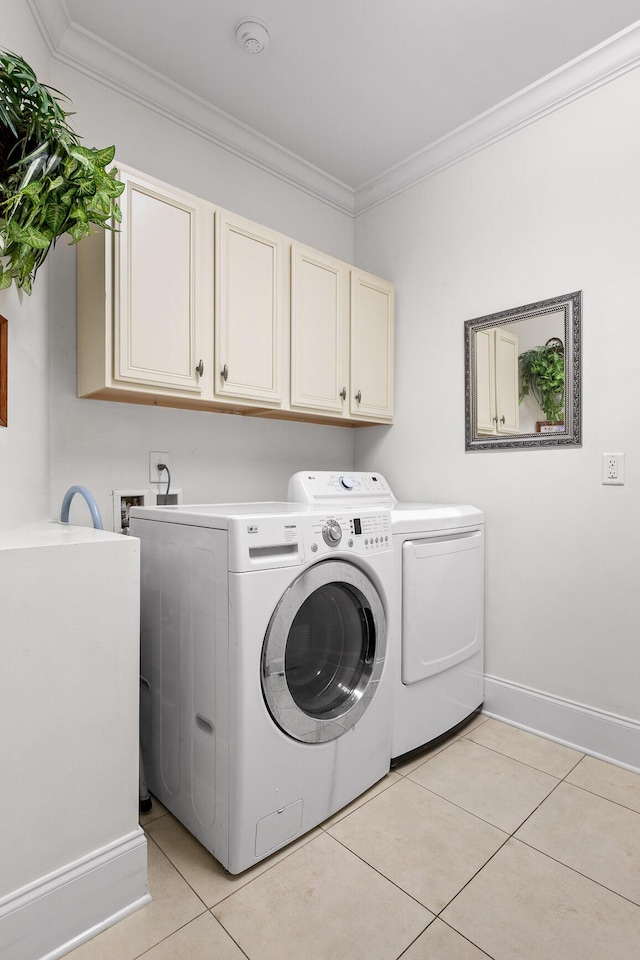 washroom with cabinets, independent washer and dryer, light tile patterned floors, and ornamental molding