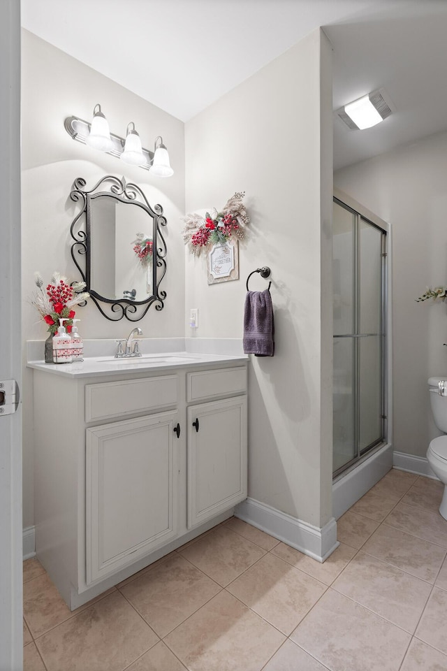 bathroom with tile patterned flooring, a shower with door, vanity, and toilet