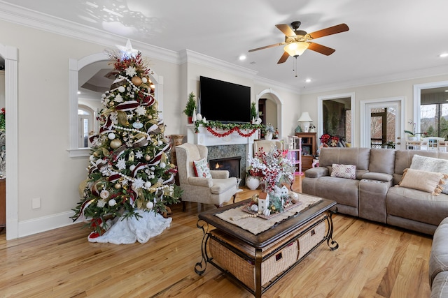 living room featuring ceiling fan, ornamental molding, and light hardwood / wood-style flooring