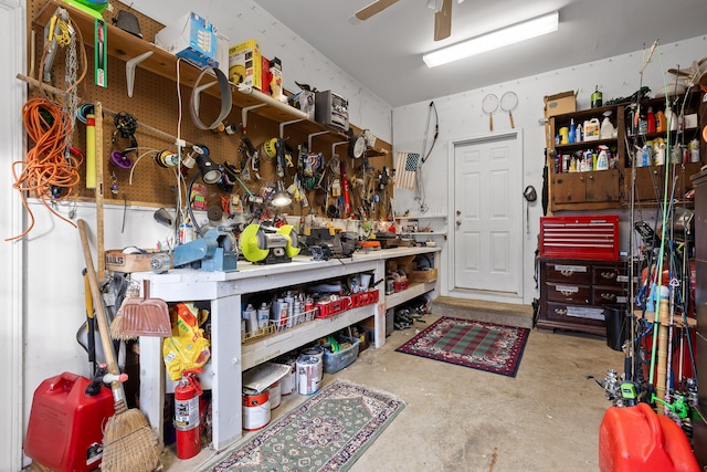 misc room with a workshop area, concrete floors, and ceiling fan