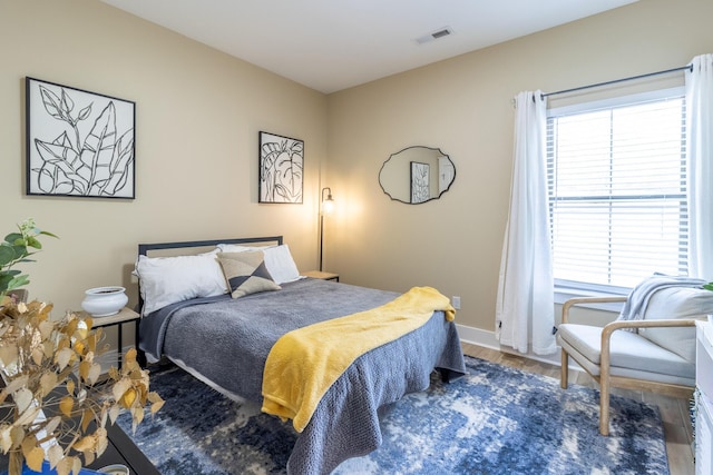 bedroom featuring wood-type flooring and multiple windows