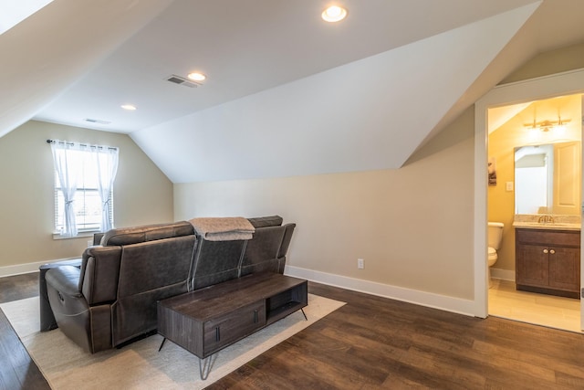 interior space featuring dark wood-type flooring, lofted ceiling, and sink