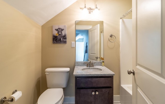 bathroom featuring toilet, vanity, and vaulted ceiling