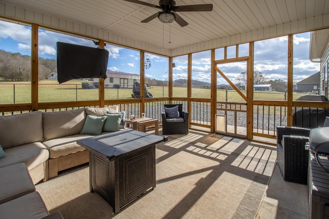 sunroom / solarium featuring ceiling fan