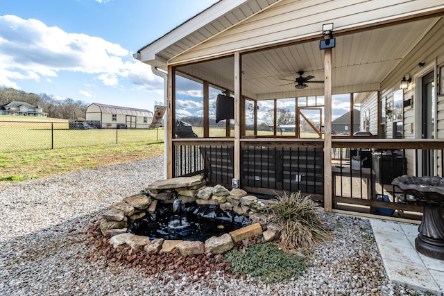 view of patio / terrace featuring ceiling fan and a sunroom