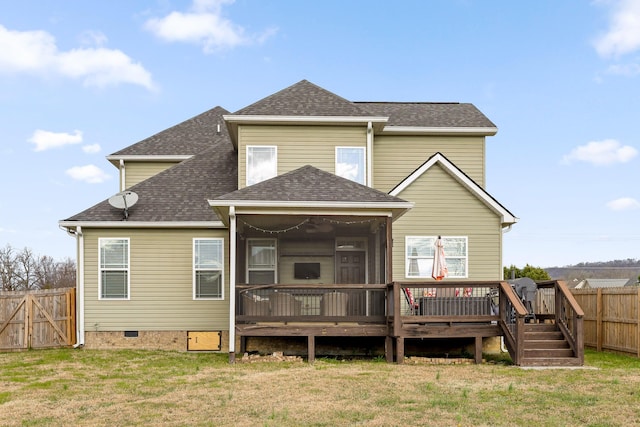 back of house featuring a lawn, a sunroom, and a wooden deck