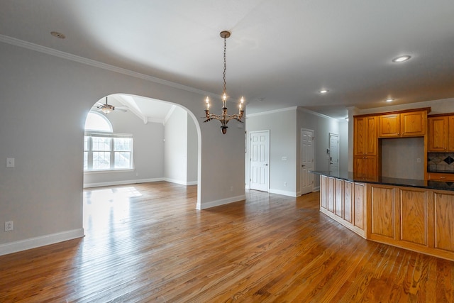 kitchen with hardwood / wood-style flooring, decorative backsplash, and crown molding