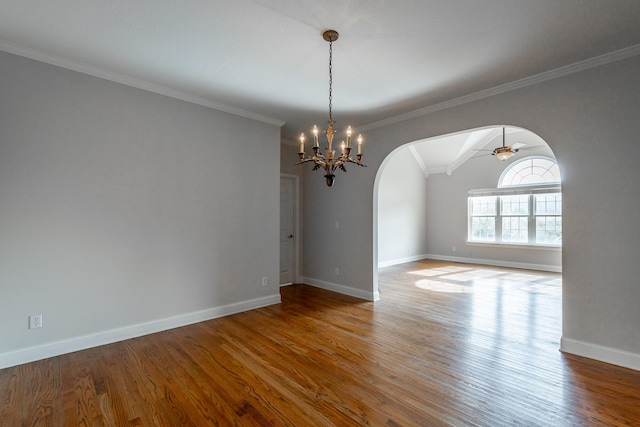 spare room featuring ceiling fan with notable chandelier, hardwood / wood-style flooring, vaulted ceiling, and crown molding