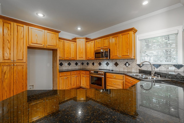 kitchen featuring dark stone counters, crown molding, sink, and stainless steel appliances