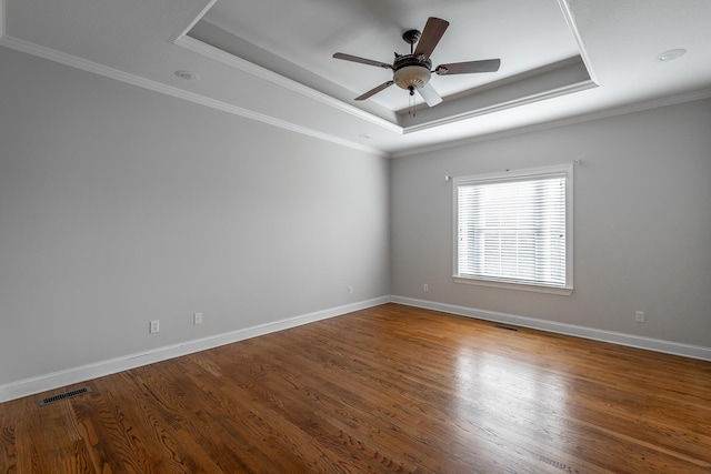 spare room with hardwood / wood-style flooring, ceiling fan, crown molding, and a tray ceiling