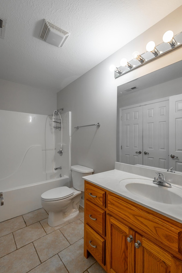 full bathroom with tile patterned flooring, vanity, a textured ceiling, and toilet