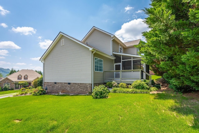 view of home's exterior with a lawn and a sunroom