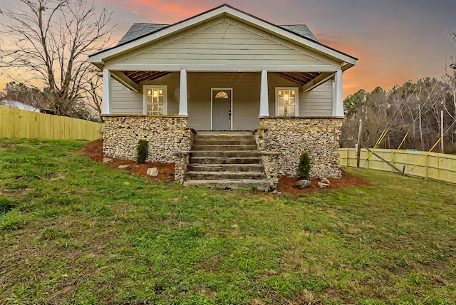 view of front facade with covered porch and a yard