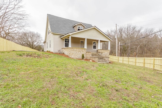 view of front of house featuring covered porch and a front yard