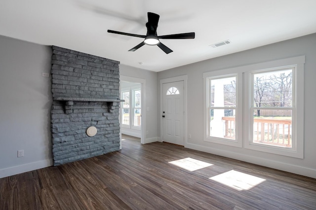 entrance foyer with a large fireplace, dark hardwood / wood-style floors, and ceiling fan