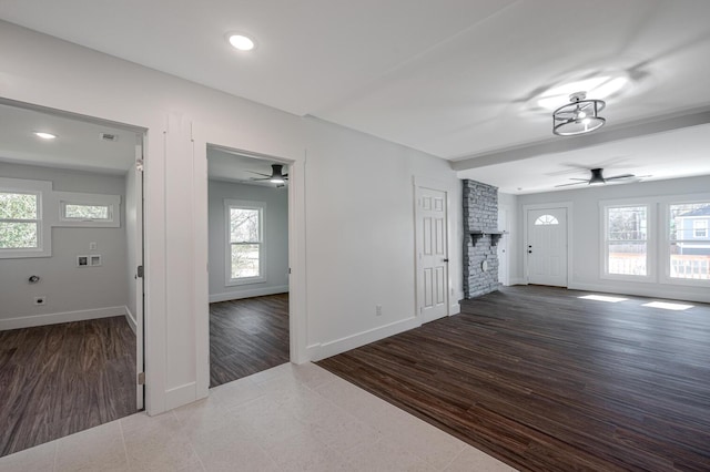 interior space featuring dark hardwood / wood-style flooring, a brick fireplace, and ceiling fan