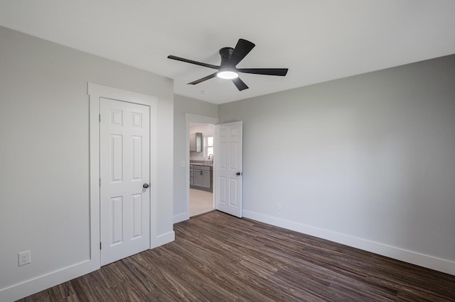 unfurnished bedroom with ceiling fan, dark wood-type flooring, and a closet