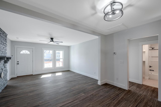 unfurnished living room with dark hardwood / wood-style flooring, ceiling fan, and a fireplace