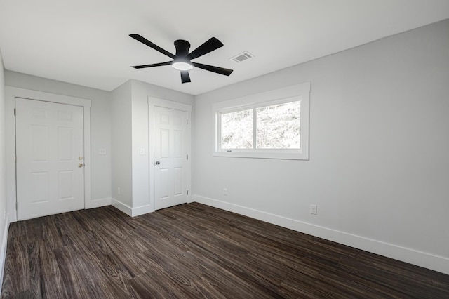 unfurnished bedroom with ceiling fan, a closet, and dark wood-type flooring