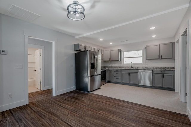 kitchen with gray cabinets, dark wood-type flooring, stainless steel appliances, and sink