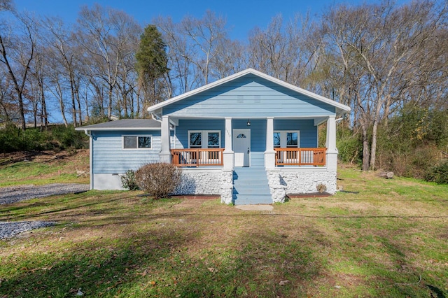 bungalow featuring covered porch and a front yard