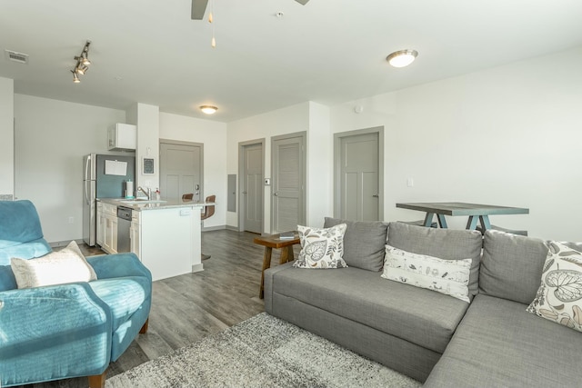 living room featuring ceiling fan, sink, and wood-type flooring