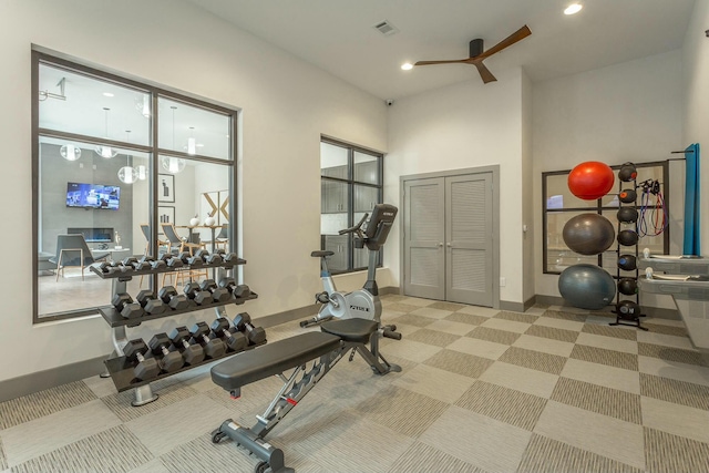 workout area featuring light colored carpet and a high ceiling