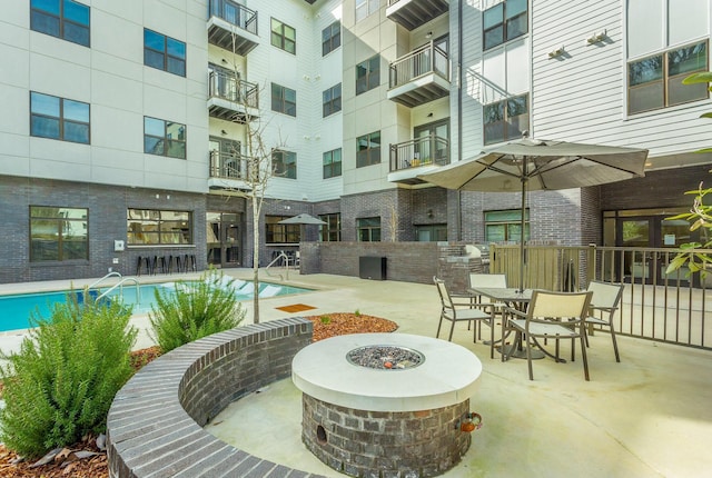 view of pool with a fire pit and a patio area