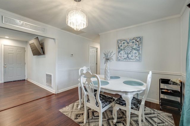 dining area with a chandelier, dark hardwood / wood-style floors, and crown molding