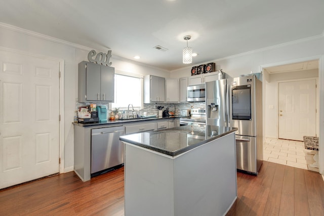 kitchen with a center island, stainless steel appliances, gray cabinets, and sink