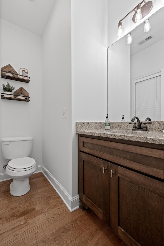 bathroom with vanity, wood-type flooring, and toilet