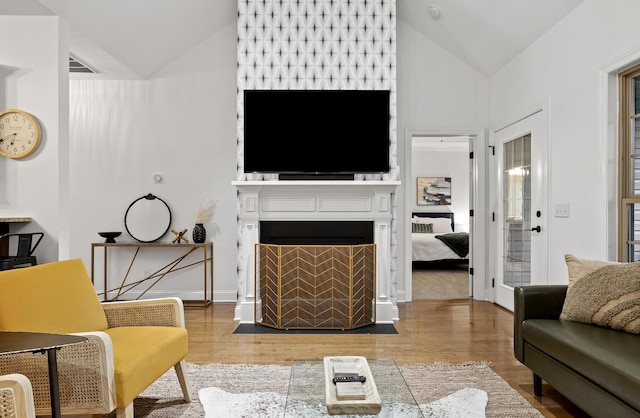 living room with light hardwood / wood-style floors and lofted ceiling