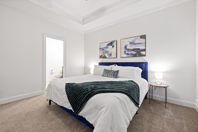 carpeted bedroom with crown molding, a tray ceiling, and ensuite bath