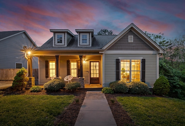 view of front facade featuring covered porch and a yard