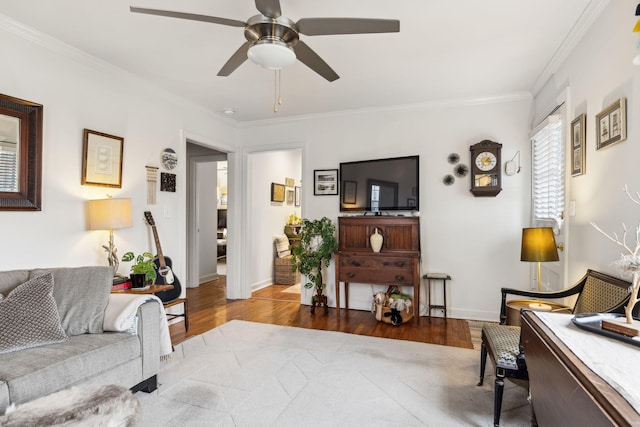 living room with hardwood / wood-style flooring, ceiling fan, and ornamental molding