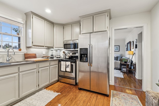 kitchen featuring gray cabinets, sink, light hardwood / wood-style floors, and appliances with stainless steel finishes