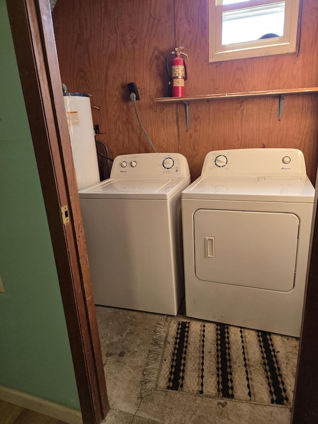 clothes washing area featuring washing machine and dryer and water heater